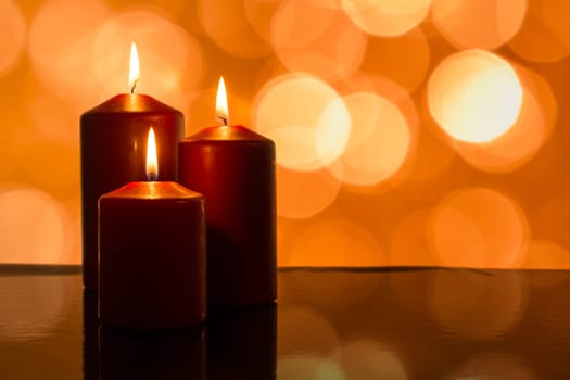 Candles burning and lights as bokeh at Christmas with reflection
