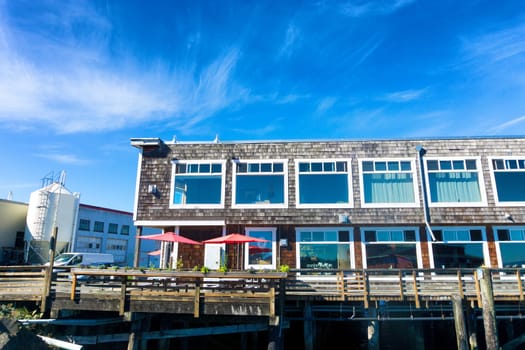 Red umbrellas add a spot of color to a building onthe waterfront in Astoria, Oregon