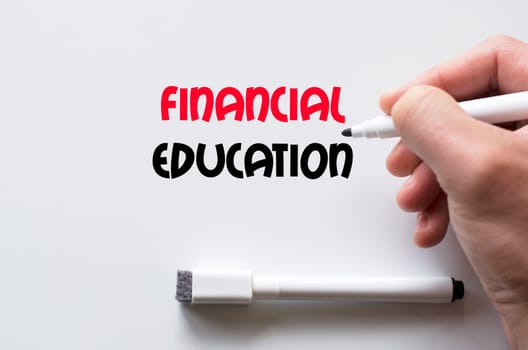 Human hand writing financial education on whiteboard