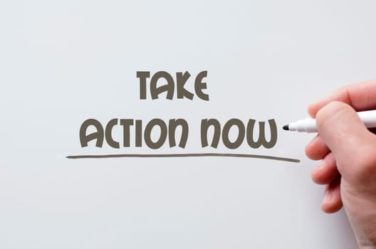 Human hand writing take action now on whiteboard