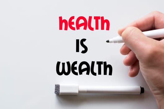 Human hand writing health is wealth on whiteboard
