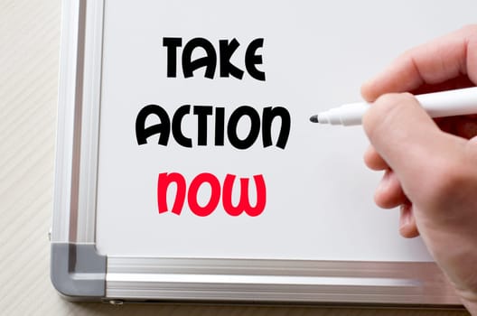 Human hand writing take action now on whiteboard