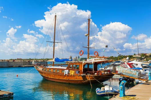NESEBAR, BULGARIA, SEPTEMBER 06, 2013: Pleasure yacht in the port of Nesebar old town. Wooden passenger sailing ship standing at the pier on the coast of the Black Sea.