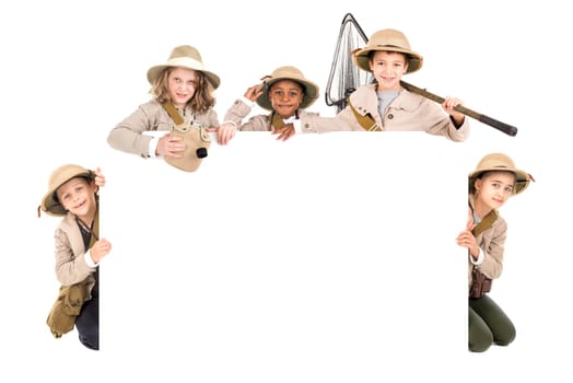 Children's group with safari clothes and gear over a white board