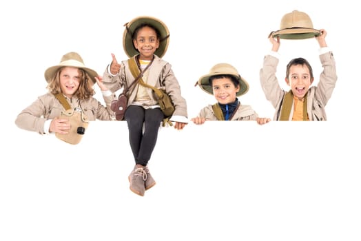 Children's group with safari clothes and gear over a white board