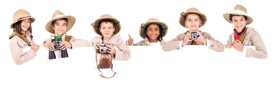 Children's group with safari clothes and gear over a white board