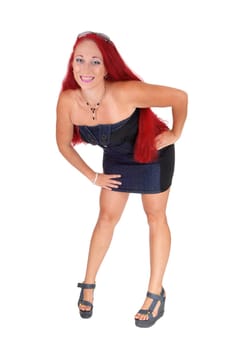 A woman with red hair wearing a jeans dress standing from the front,.isolated for white background..