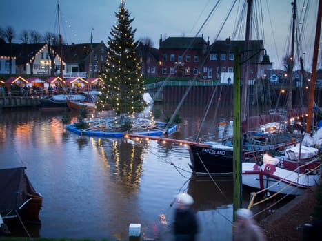 Port of Carolinensiel with floating Christmas tree at dusk