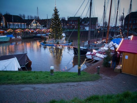 Port of Carolinensiel with floating Christmas tree at dusk