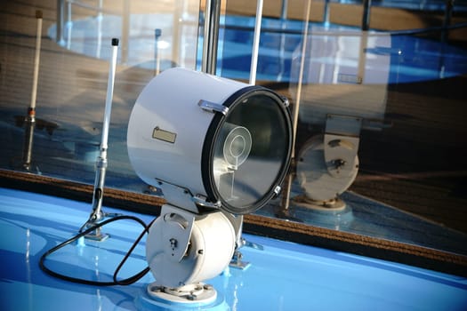 The close-up of a floodlight on the bow of a yacht.