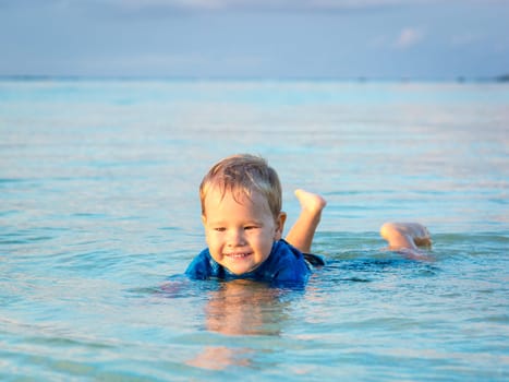 Cute boy plays in a sea