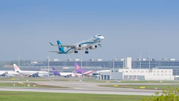 Munich, Germany - May 6, 2016: Plane Embraer E-Jet ERJ-195 of Air Dolomiti airlines taking off and gaining altitude from Munich international passenger airport.