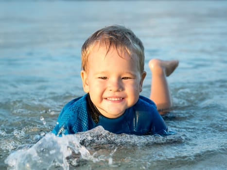 Cute boy plays in a sea