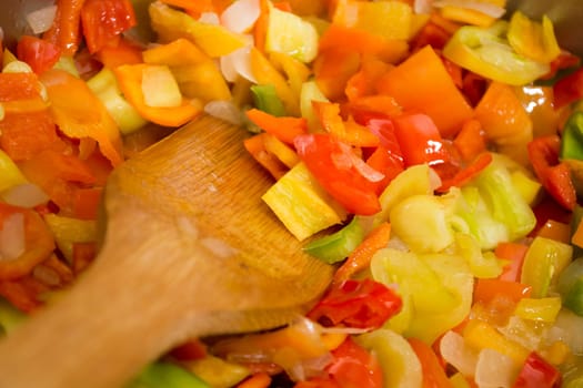Cooking stew with fresh vegetables in a pot. Mixing it with mixing spoon