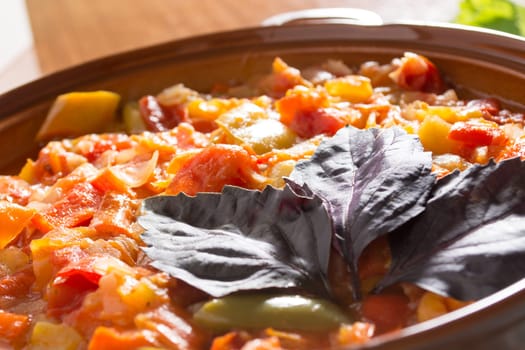 Closeup of delicious stew with mixed vegetables, arranged with green and purple leaves