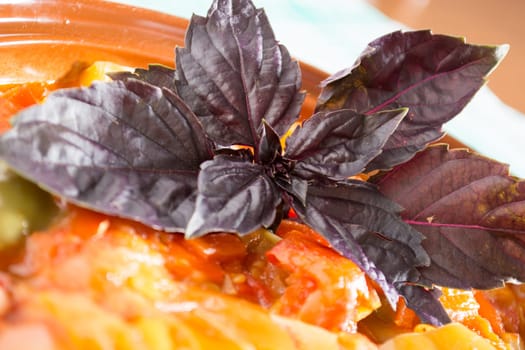 Closeup of delicious stew with mixed vegetables, arranged with purple leaves