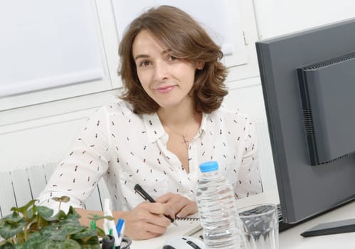 pretty young business woman working at pc in her office