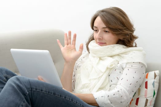 Beautiful young woman woman with a computer tablet in the sofa