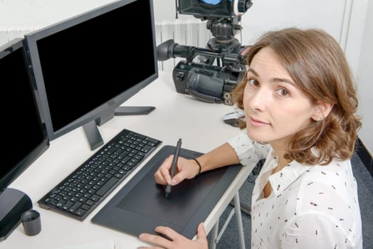 young woman designer using graphics tablet for video editing