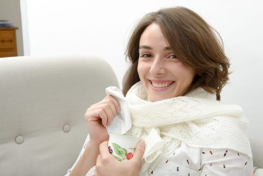 young woman is suffering from a cold and drink tea