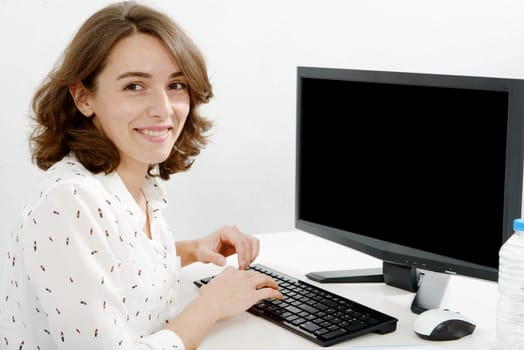 pretty young business woman working at pc in her office