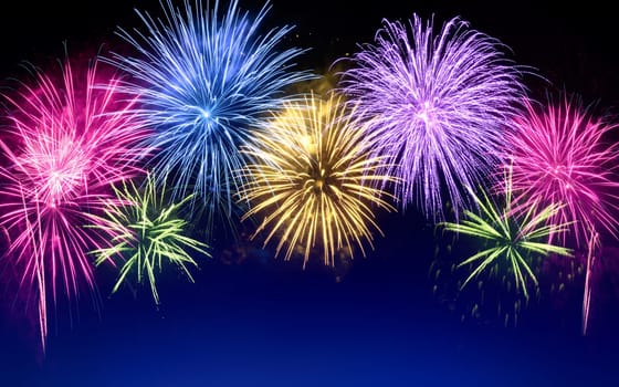 Gorgeous multi-colored fireworks as an arch shaped border on dark blue background,ideal for New Year or other celebration events