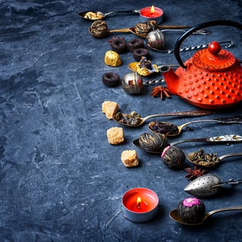 set tea leaves in stylish tea spoon on slate background