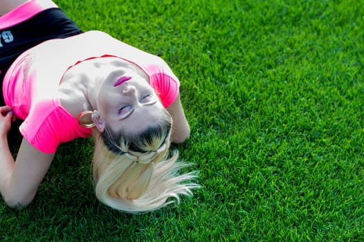 the blonde who has thrown back the head lying on the football field, a subject beautiful women, sport, events