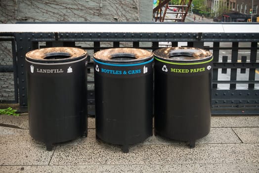 three trash bins for different types of garbage in the streets of new york