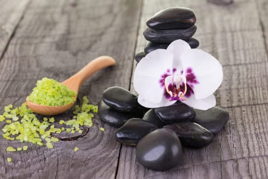 Spa with bath salt and hot stones on wooden background