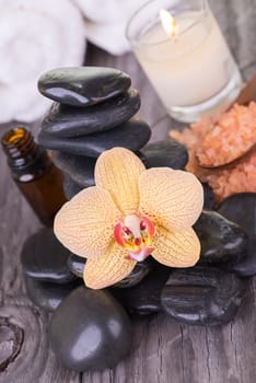 Spa with hot stones, bath salt, essential oil and towels close up