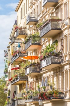 Traditional European residential house with balconys with colorful flowers and flowerpots. Kreuzberg neighborhood, Berlin, Germany