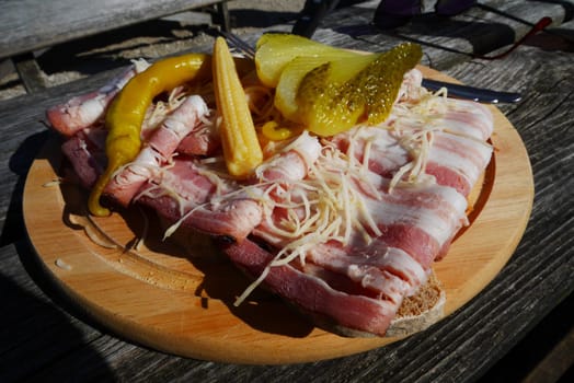 Hearty snack plate with bacon and cucumbers