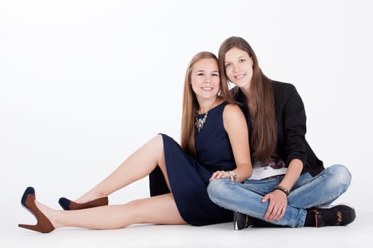 Two happy young girls on a white background in the studio