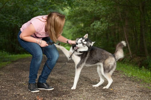 Young woman and her husky in the forest