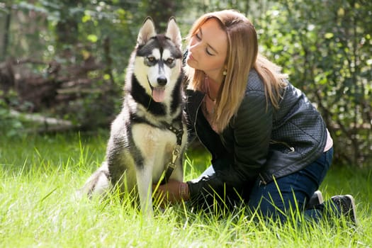 Young woman and her husky in the forest