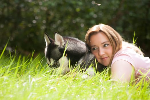 Young woman and her husky in the forest