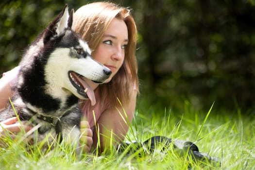 Young woman and her husky in the forest