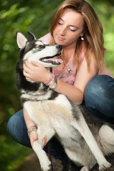 Young woman and her husky in the forest