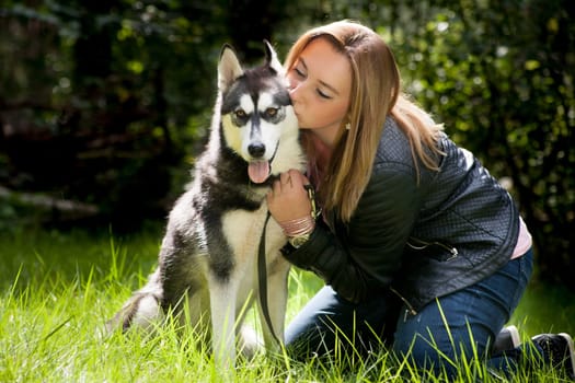 Young woman and her husky in the forest