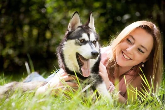 Young woman and her husky in the forest