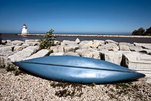 Lighthouse on Lake Huron rocks and blue canoe