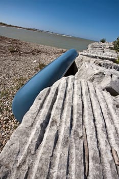 Lighthouse on Lake Huron rocks and blue canoe