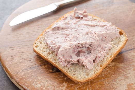 Bread rolls with wild boar liver sausage on a wooden board