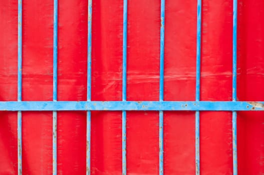 Blue iron fence and red background