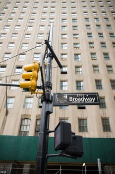 broadway street sign with yellow traffic lights in new york city