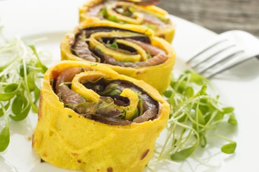 Pancakes stuffed with salmon and lettuce on a plate