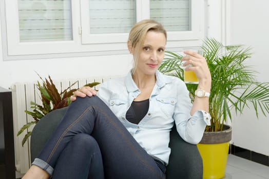 beautiful smiling blond woman drink orange juice