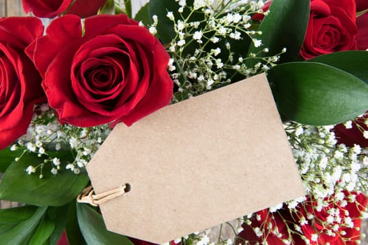 Red roses and baby's breath and gift tag with copy space