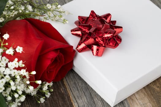 Close up of red rose and gift with red ribbon.